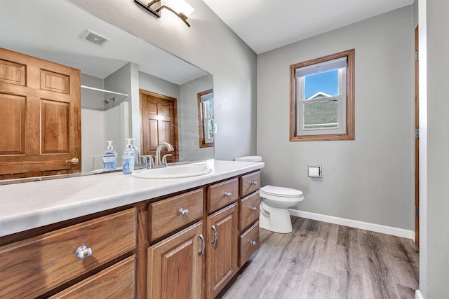 full bathroom featuring vanity, wood finished floors, visible vents, baseboards, and toilet