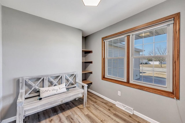 interior space featuring visible vents, baseboards, and wood finished floors