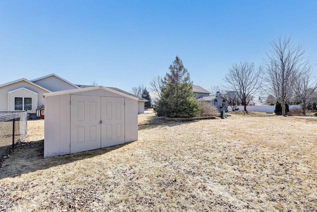 view of yard with an outdoor structure, fence, and a shed