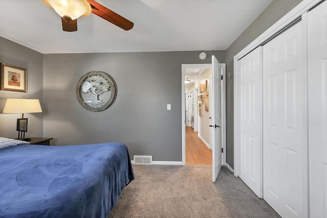 bedroom with a ceiling fan, carpet, visible vents, baseboards, and a closet