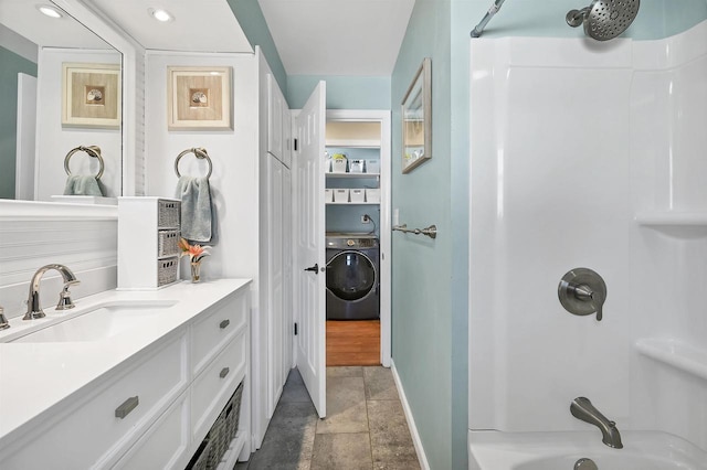 bathroom with vanity, stone finish floor, washer / clothes dryer, and shower / washtub combination