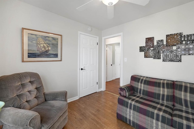 sitting room featuring baseboards, wood finished floors, and a ceiling fan