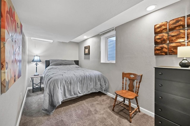 carpeted bedroom featuring recessed lighting, baseboards, and a textured wall