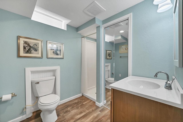 full bath featuring vanity, toilet, wood finished floors, and visible vents