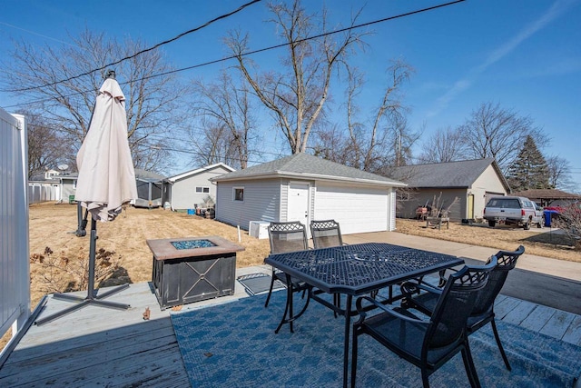 view of patio with a garage, an outbuilding, outdoor dining space, and an outdoor fire pit