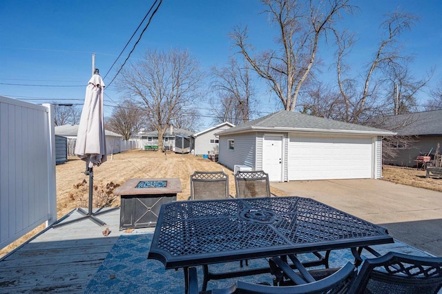 exterior space with a garage, a fire pit, an outdoor structure, and fence