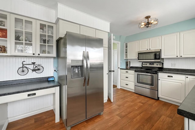 kitchen featuring dark countertops, dark wood-style floors, white cabinetry, and stainless steel appliances