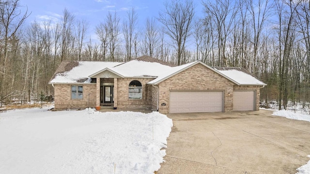 ranch-style home with brick siding, an attached garage, and driveway