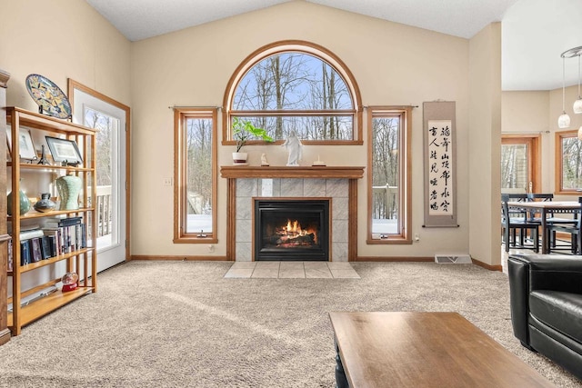 living area with carpet flooring, a fireplace, visible vents, and vaulted ceiling