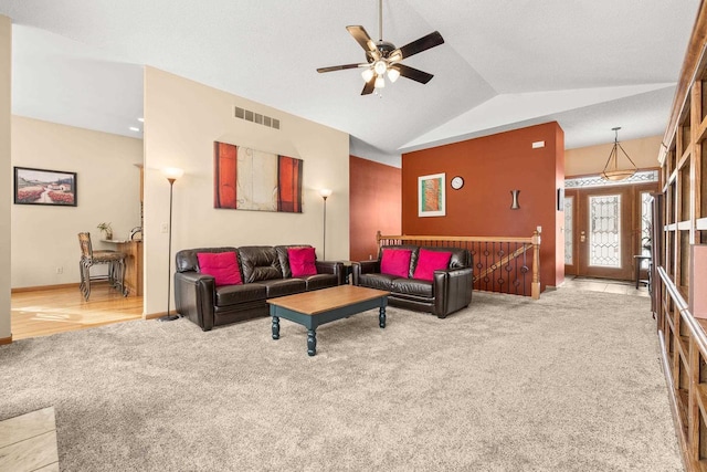 living area featuring visible vents, a ceiling fan, carpet flooring, baseboards, and vaulted ceiling