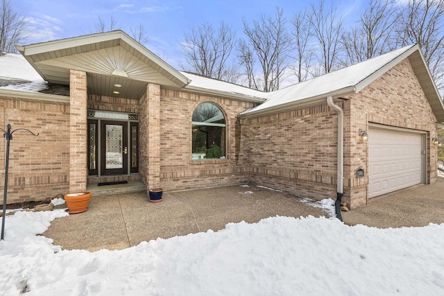 view of front of home featuring brick siding, driveway, and a garage