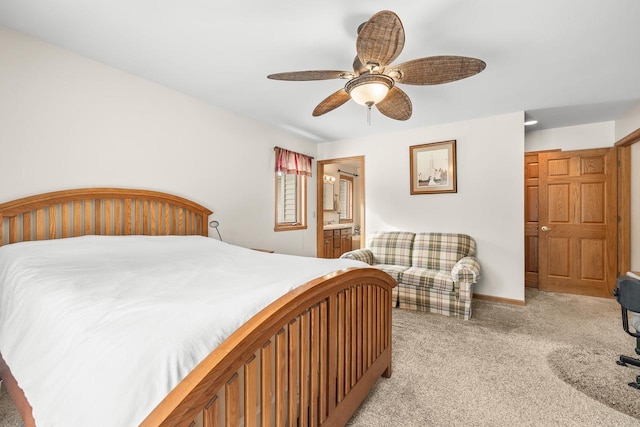 bedroom with baseboards, light carpet, ensuite bath, and a ceiling fan