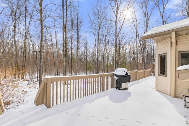 snow covered deck with a grill