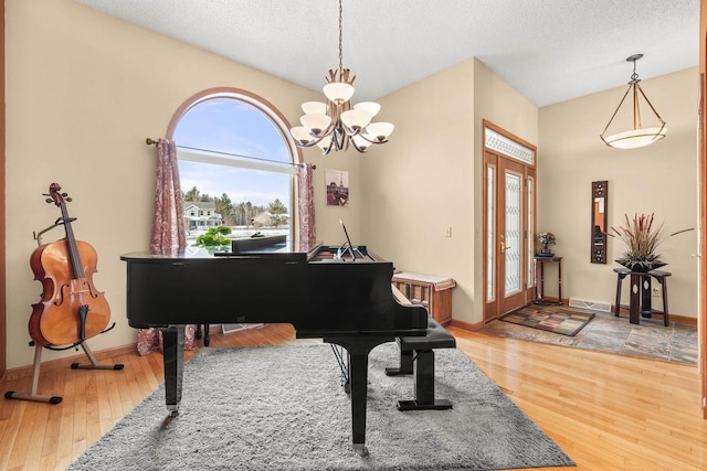 living area with baseboards, visible vents, light wood finished floors, and a textured ceiling