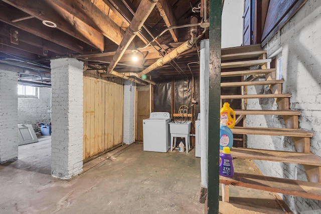 below grade area featuring stairs, washer / clothes dryer, and a sink