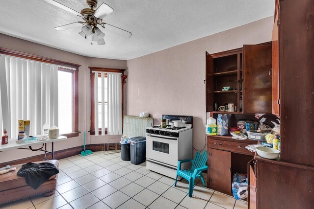 kitchen with white range with gas cooktop, a ceiling fan, open shelves, a textured ceiling, and light tile patterned floors