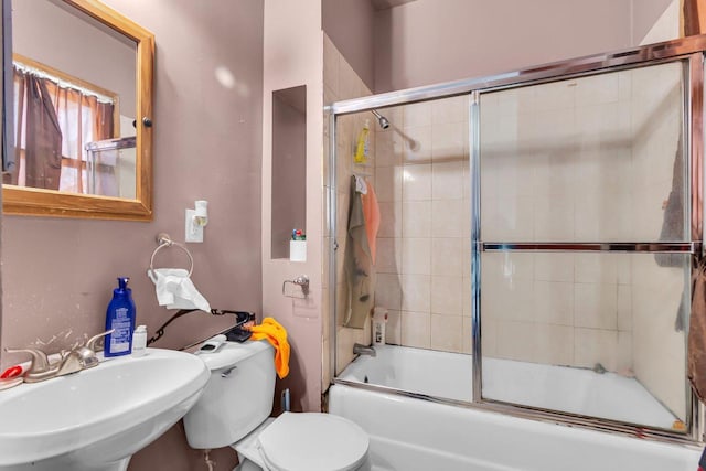 full bathroom with enclosed tub / shower combo, toilet, and a sink