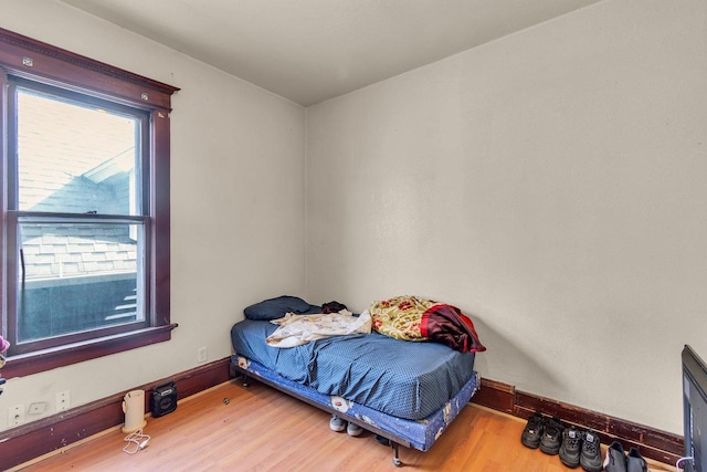 bedroom featuring baseboards and wood finished floors