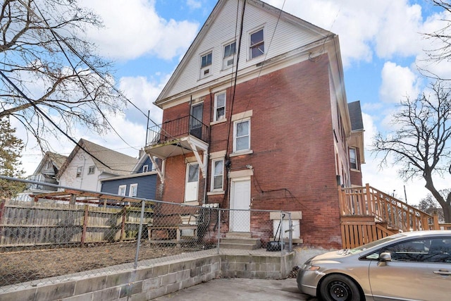 view of front facade with brick siding and fence