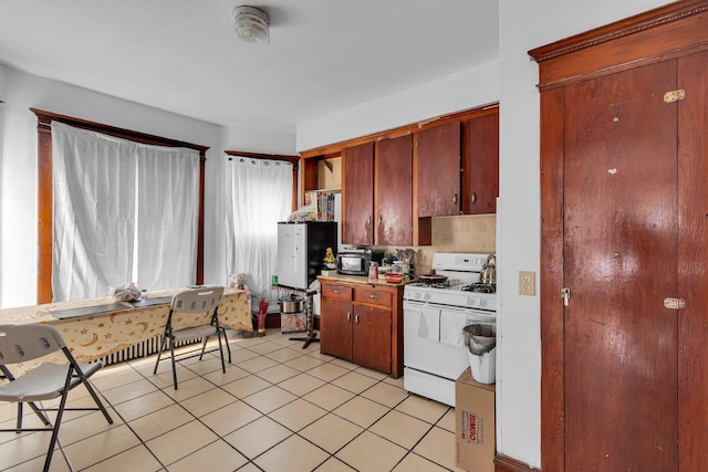 kitchen with white range with gas cooktop and light tile patterned floors