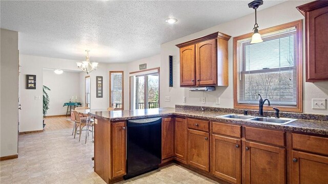 kitchen featuring dishwasher, dark countertops, brown cabinetry, and a sink