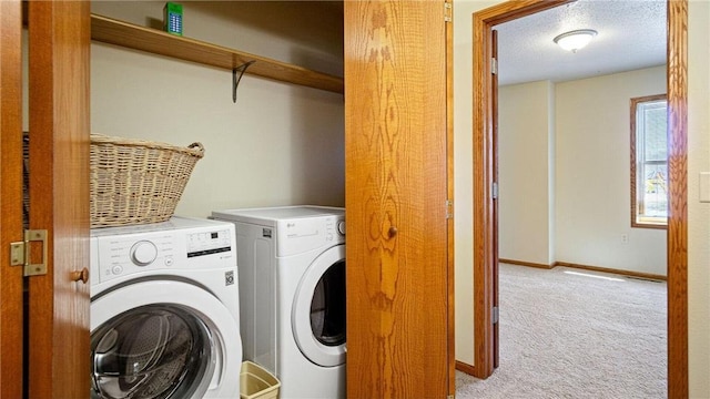 laundry room with light carpet, a textured ceiling, washing machine and dryer, baseboards, and laundry area