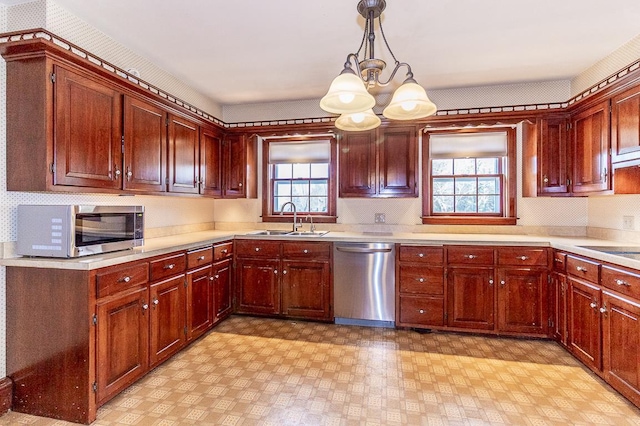 kitchen with light countertops, a wealth of natural light, appliances with stainless steel finishes, and a sink