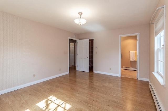 unfurnished room with wallpapered walls and a baseboard radiator