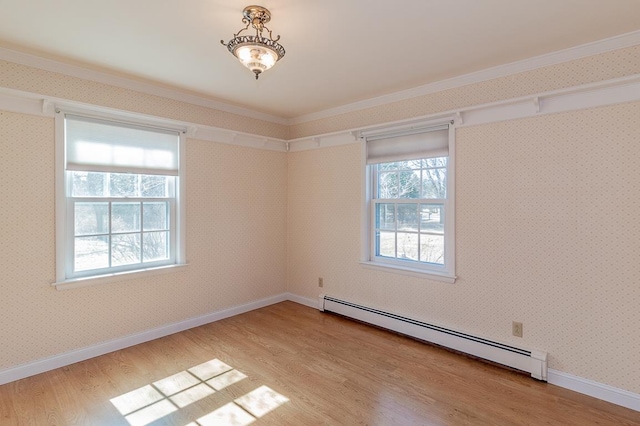 spare room with baseboards, baseboard heating, wood finished floors, and wallpapered walls