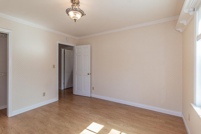 unfurnished bedroom featuring wallpapered walls, crown molding, and light wood finished floors