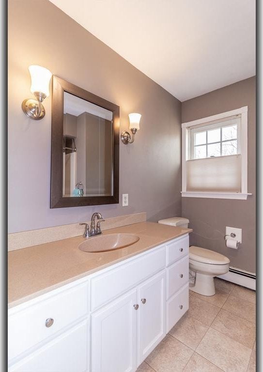 bathroom featuring tile patterned floors, toilet, vanity, and a baseboard radiator