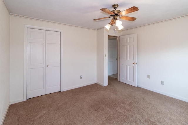 unfurnished bedroom with a closet, a ceiling fan, baseboards, and carpet floors