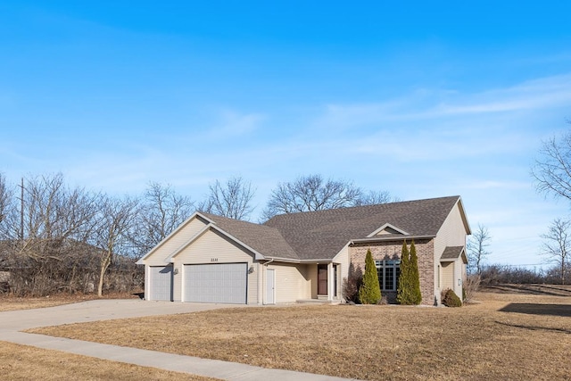 ranch-style home with brick siding, a front lawn, concrete driveway, roof with shingles, and an attached garage