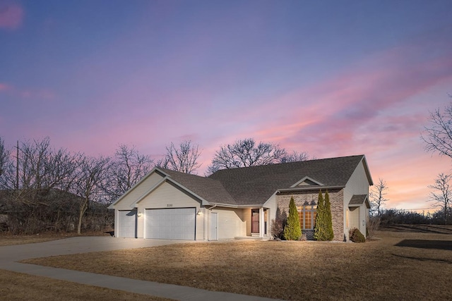 single story home with brick siding, a garage, a front lawn, and driveway