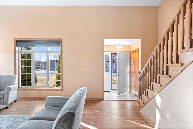 entryway featuring baseboards, wood finished floors, and stairs