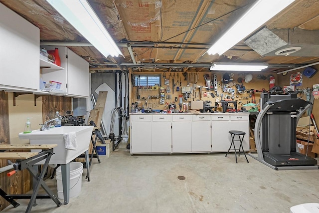 basement with a workshop area, visible vents, and a sink