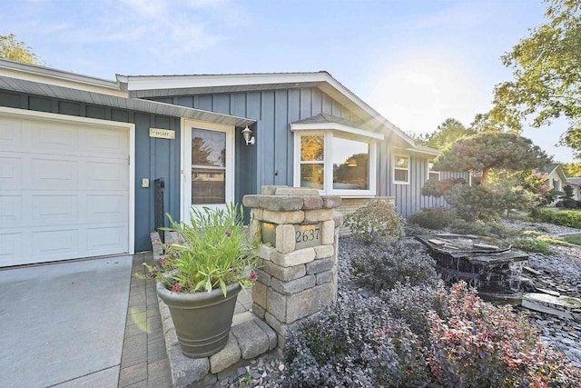 view of exterior entry featuring a garage and board and batten siding