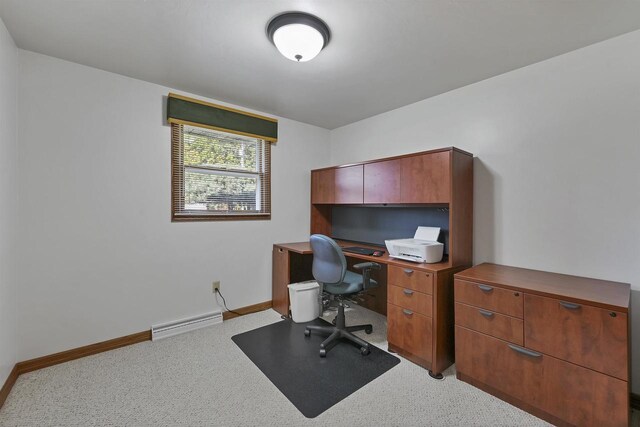 office space with a baseboard heating unit and baseboards