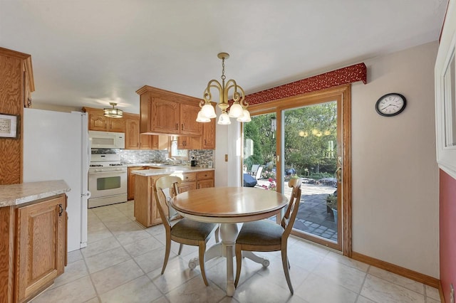 dining space featuring an inviting chandelier and baseboards