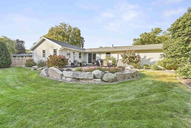 rear view of property with a yard, a patio area, and fence