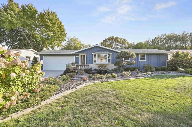 single story home featuring brick siding, an attached garage, concrete driveway, and a front yard