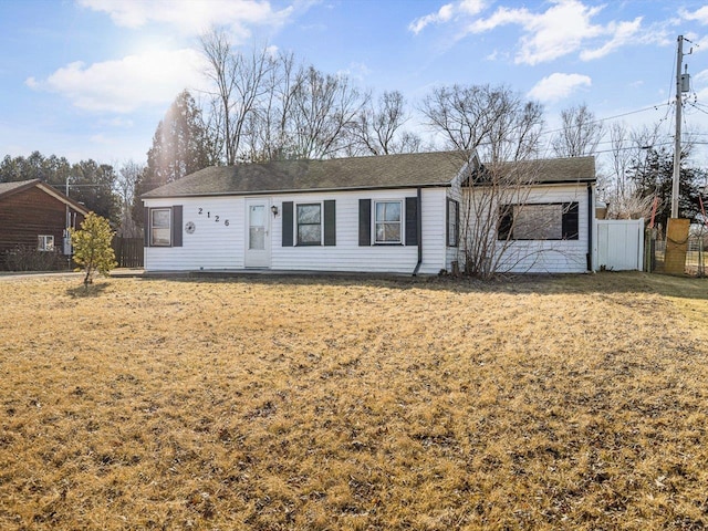 ranch-style house with a front yard and fence