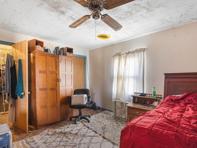 bedroom featuring visible vents, a textured ceiling, and a ceiling fan