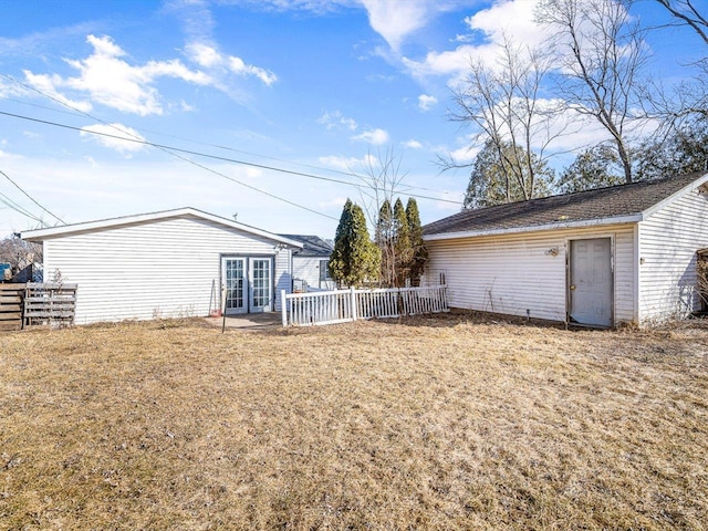 view of yard with french doors, an outdoor structure, and fence