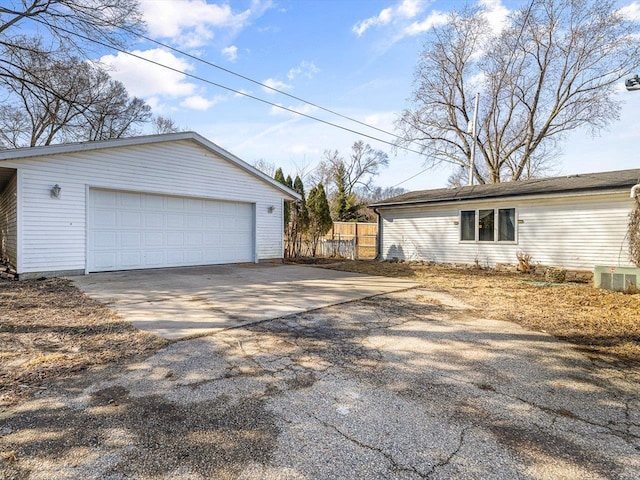 view of property exterior featuring an outdoor structure, a garage, and fence