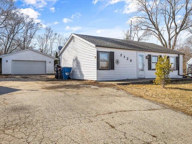 single story home with an outdoor structure and a detached garage