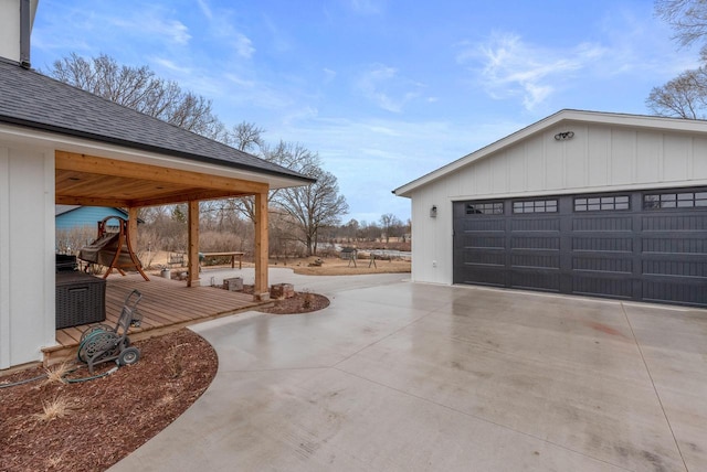 exterior space with a detached garage and a wooden deck