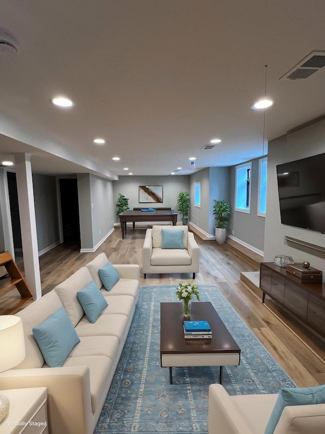 living area with recessed lighting, wood finished floors, visible vents, and baseboards