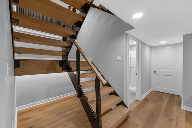 stairway with recessed lighting, baseboards, and wood finished floors