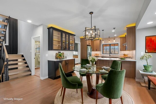 dining space featuring a notable chandelier, light wood-style flooring, recessed lighting, stairway, and baseboards